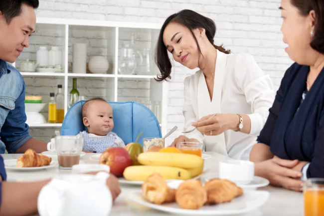 Happy family at dining table with Myanmar maid Indonesian maid agency in Singapore